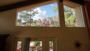 A room with a large window overlooking a rocky landscape with trees. - Quail Hollow Retreat (Sedona)