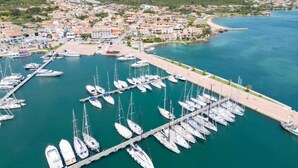 A marina with numerous sailboats docked, surrounded by a coastal town with buildings and hills in the background. - Apartment  Trudi by Interhome (Cannigione)