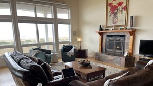 Ein Wohnzimmer mit Kamin, Ledersofas, einem Couchtisch und einem Fernseher.