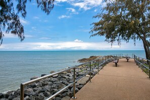A coastal walkway with benches and a railing, leading to the sea. - Beachfront Apartment with Ocean Views (Yorkeys Knob)