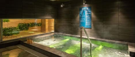 A hot tub with a wooden wall and a signboard.