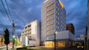 Un SuperHotel amb múltiples pisos, un disseny modern i una entrada ben il·luminada.