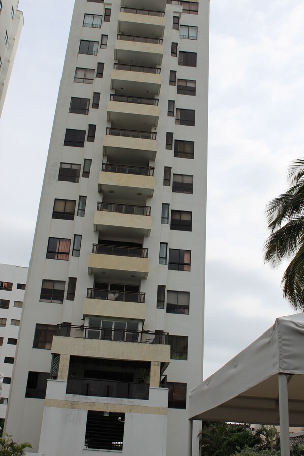 Un edificio alto de varios pisos, con balcones y ventanas.