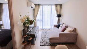 Una sala de estar moderna con un sofá, una mesa de centro y una mesita auxiliar con objetos decorativos.