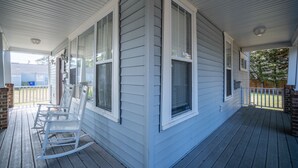 A covered porch with white rocking chairs, a brick wall, and a wooden deck. - 2 Blocks to Beach, 5 Beds, Deck, Grill, Fire Pit, Stocked Kitchen, FIOS (Norfolk)