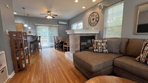 A living room with a fireplace, a dining area, and a ceiling fan. - 2 Blocks to Beach, 5 Beds, Deck, Grill, Fire Pit, Stocked Kitchen, FIOS (Norfolk)