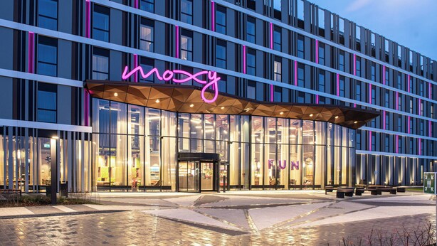 Een modern gebouw met een neonbord waarop 