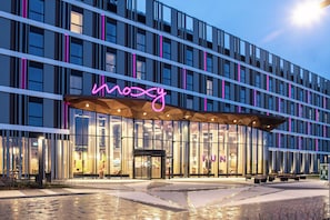 A modern building with a neon sign reading "mozy" and a glass facade. - Moxy Poznan Airport (Poznan)