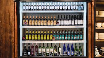 A refrigerated display case with various bottles of beverages, including wine and beer, arranged on shelves.