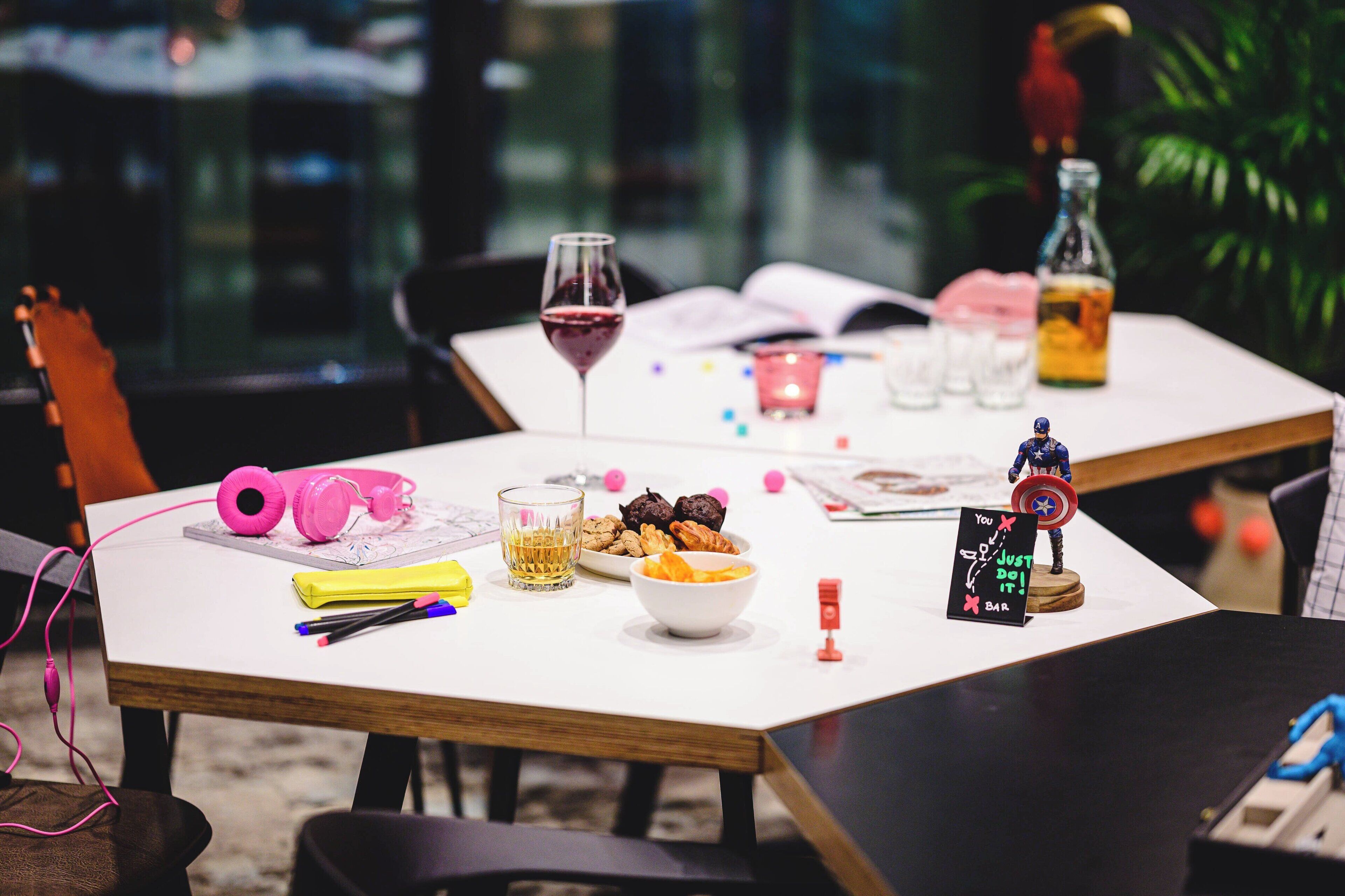 A table with a glass of wine, snacks, a small figurine, and a sign that reads "You just do it."