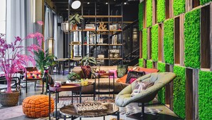 Een moderne woonkamer met een groene wand, een boekenkast en een bank.