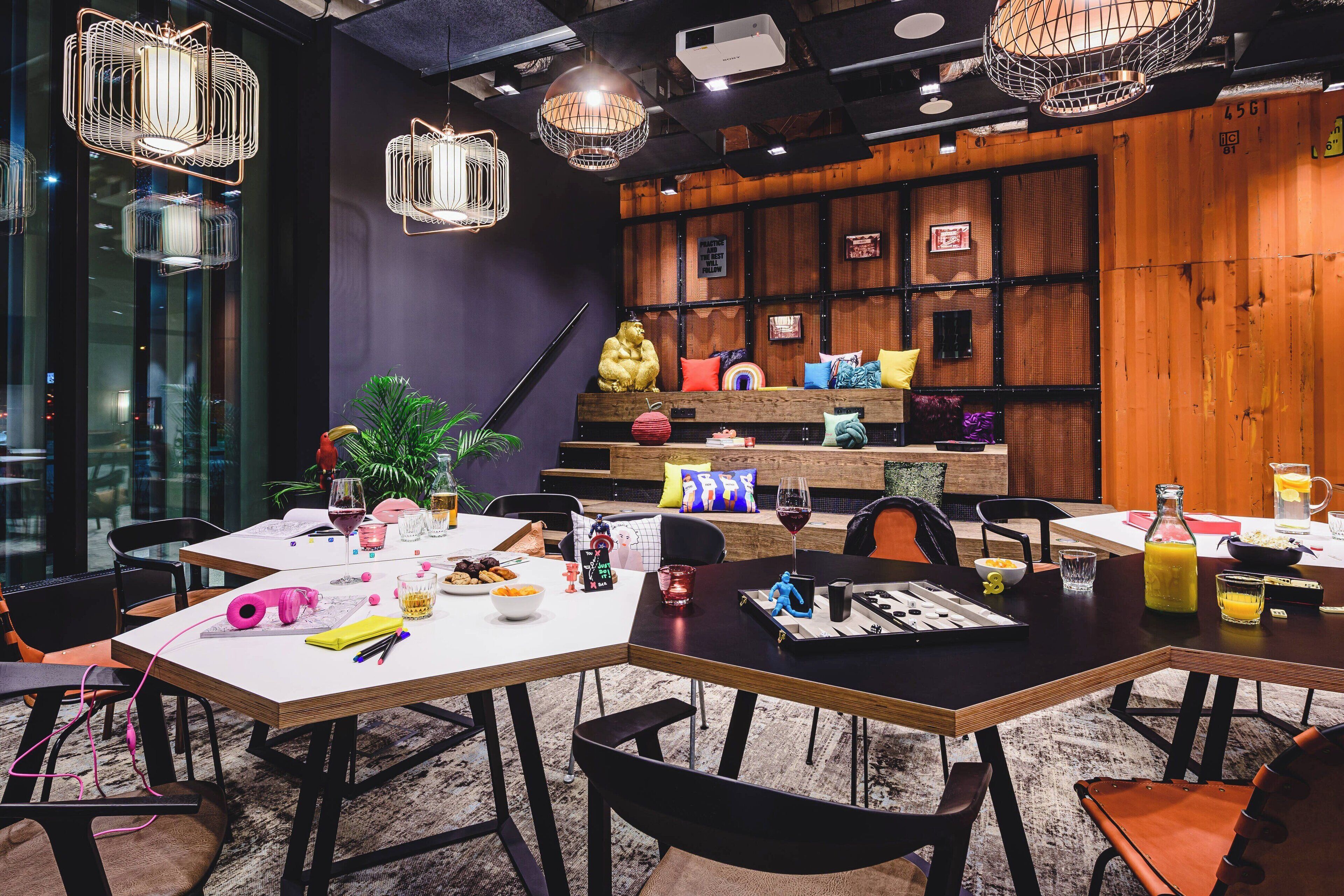 A modern dining area with tables, chairs, and a variety of food and drink items.