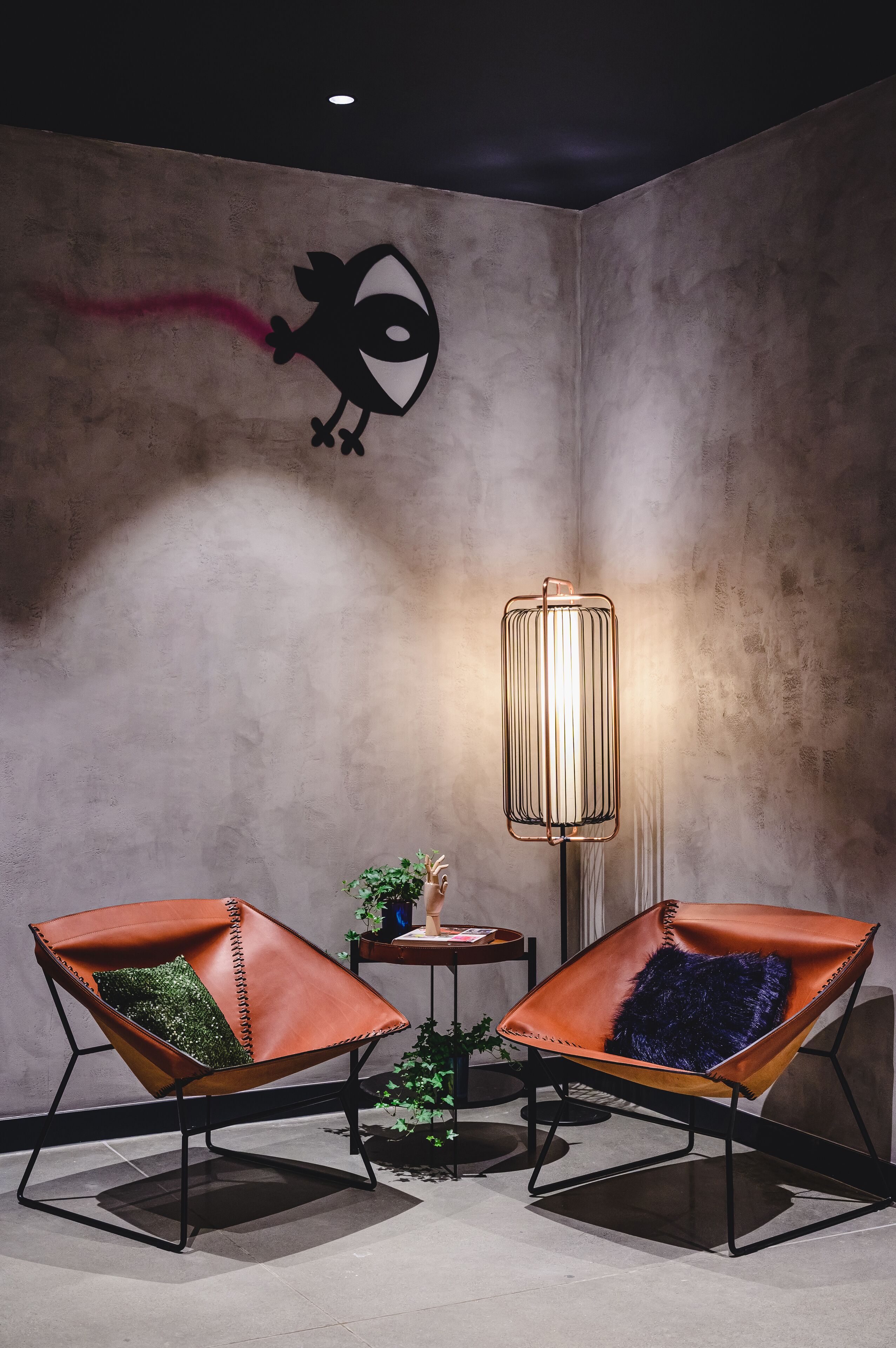 Una habitación con dos sillones de cuero, una lámpara de pie y una pared decorada con un diseño similar a un grafiti.