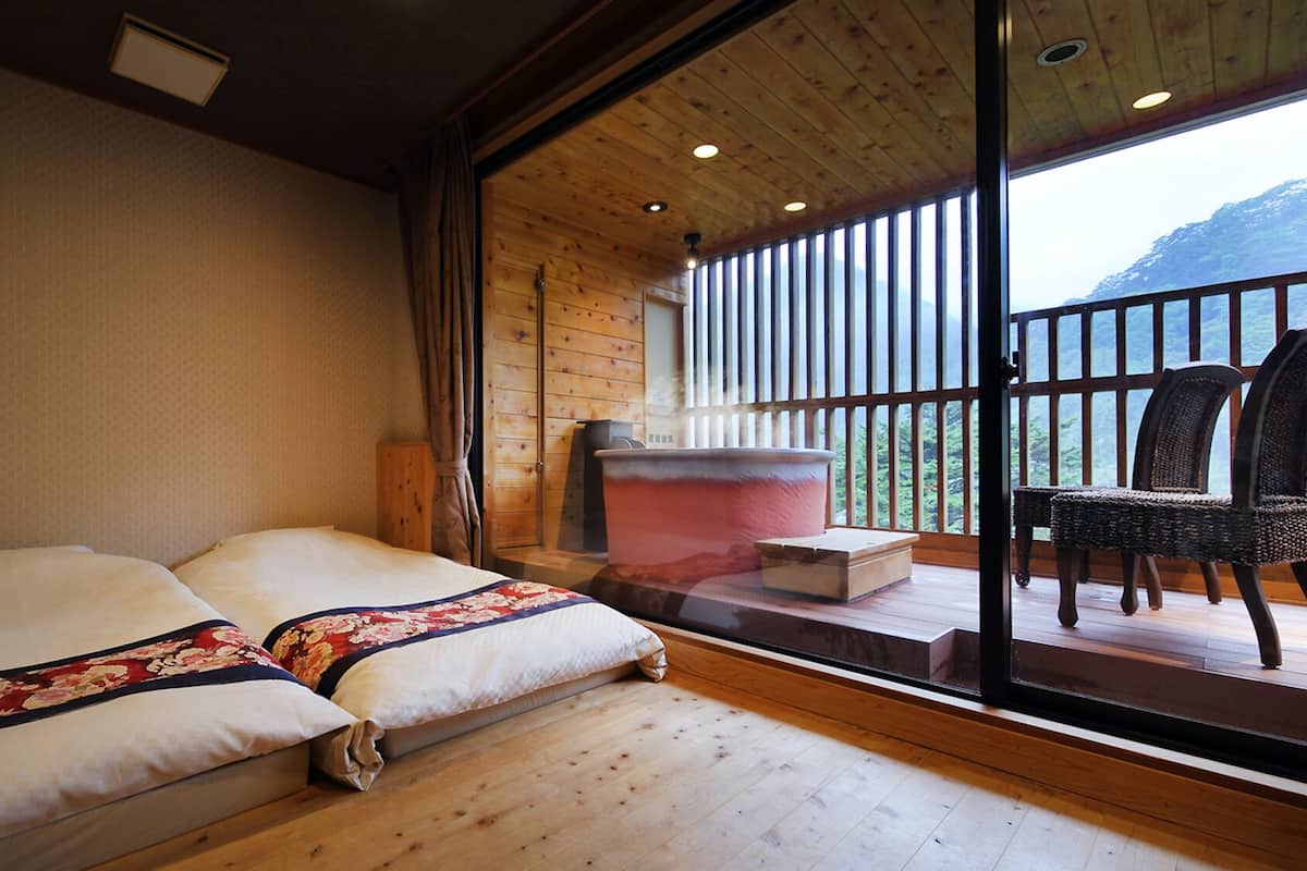 Um quarto com uma cama, uma janela grande e vista para o exterior.