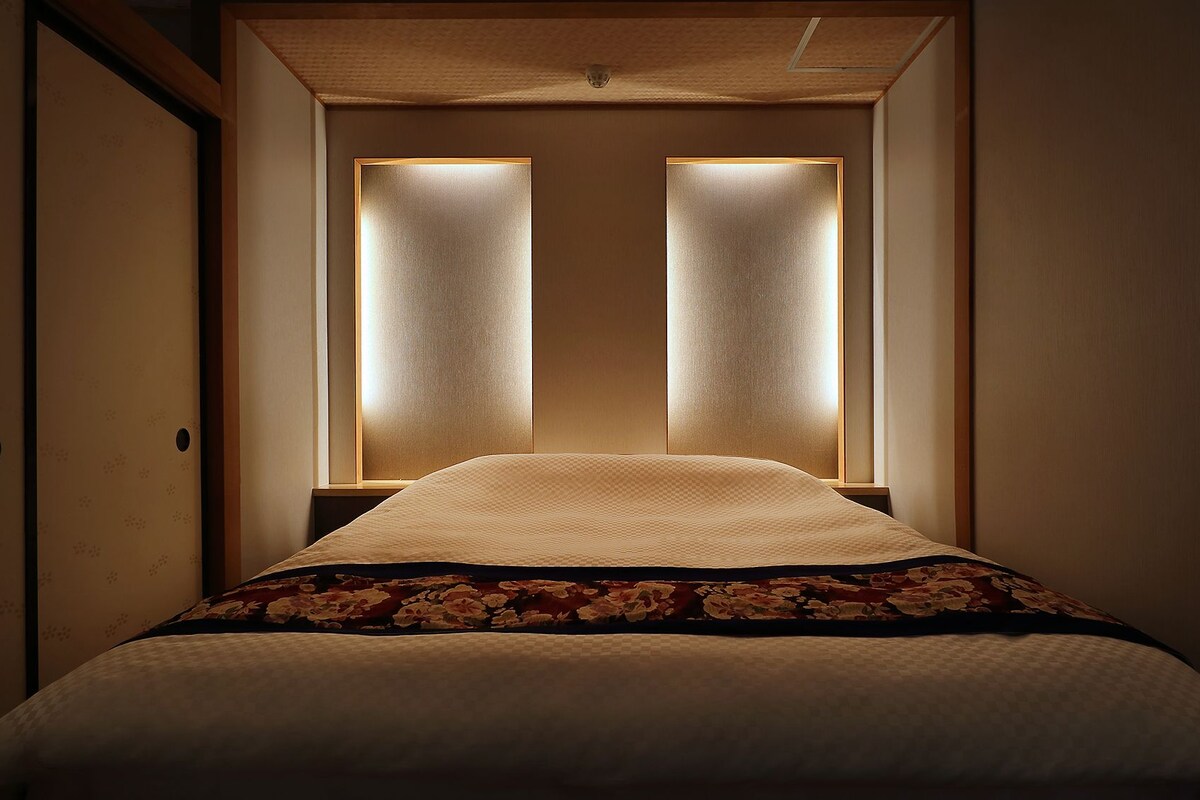 Ein Hotelzimmer mit einem Bett, zwei Nachttischlampen und einer gemusterten Tagesdecke.