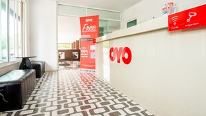 A reception area with a patterned floor, a reception desk with a large 'OYO' logo, and promotional banners offering free WiFi and 24-hour CCTV. - The Space Huahin (Hua Hin)
