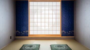 A traditional Japanese room with tatami flooring, a shoji screen, and a futon bed.