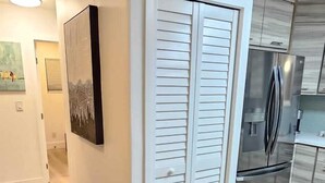 A modern kitchen with white cabinetry and a stainless steel refrigerator.