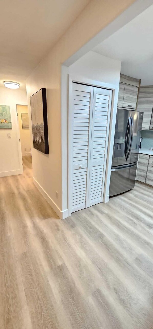Una cocina moderna con armarios blancos y un refrigerador de acero inoxidable.