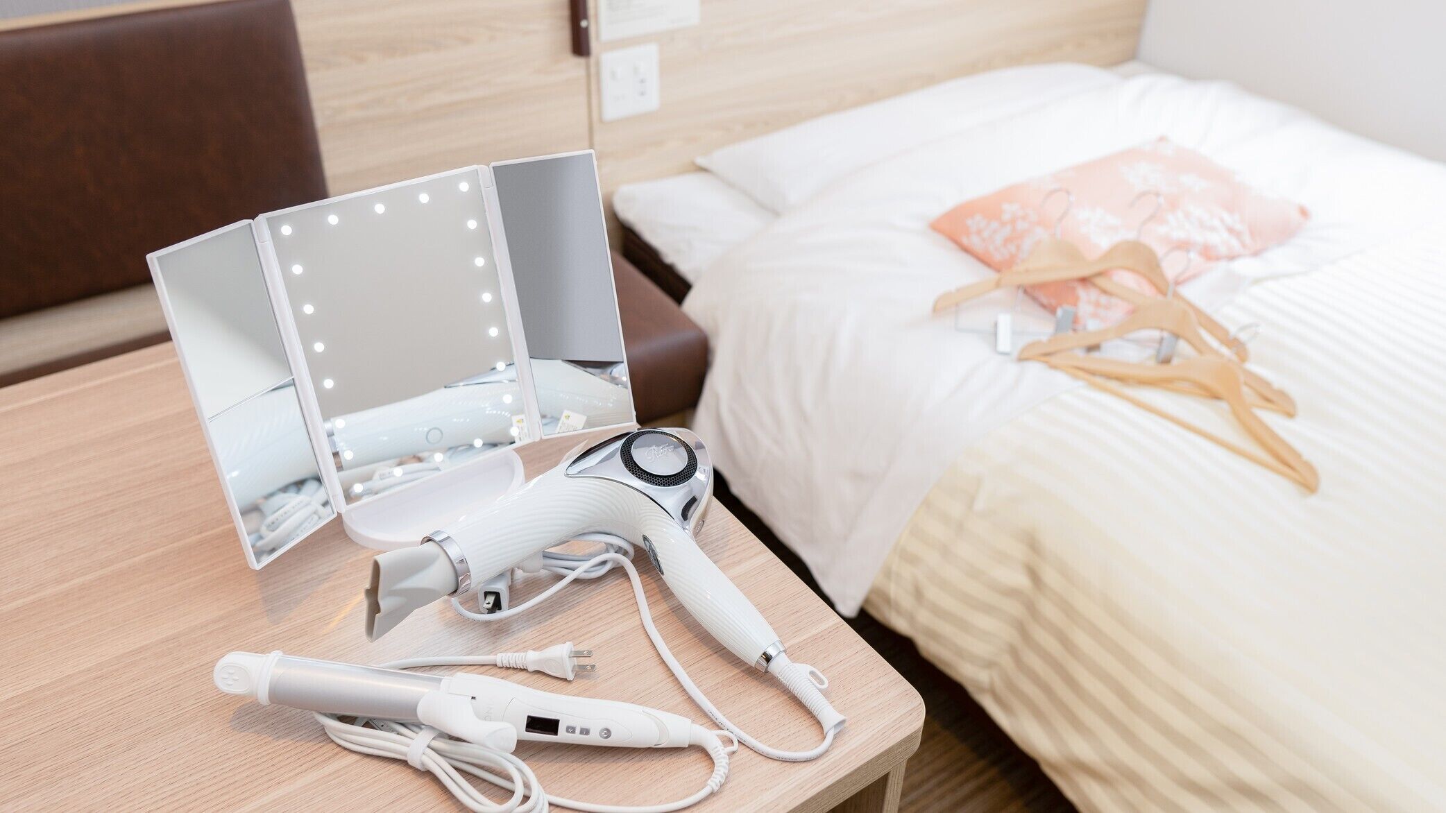 Une chambre d’hôtel équipée d’un lit, d’une table de chevet avec un sèche-cheveux, d’un miroir et d’une multiprise.