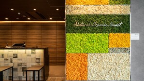A reception area with a wooden panel wall and a textured wall display. - Superhotel Premier Obihiro ekimae (Obihiro)