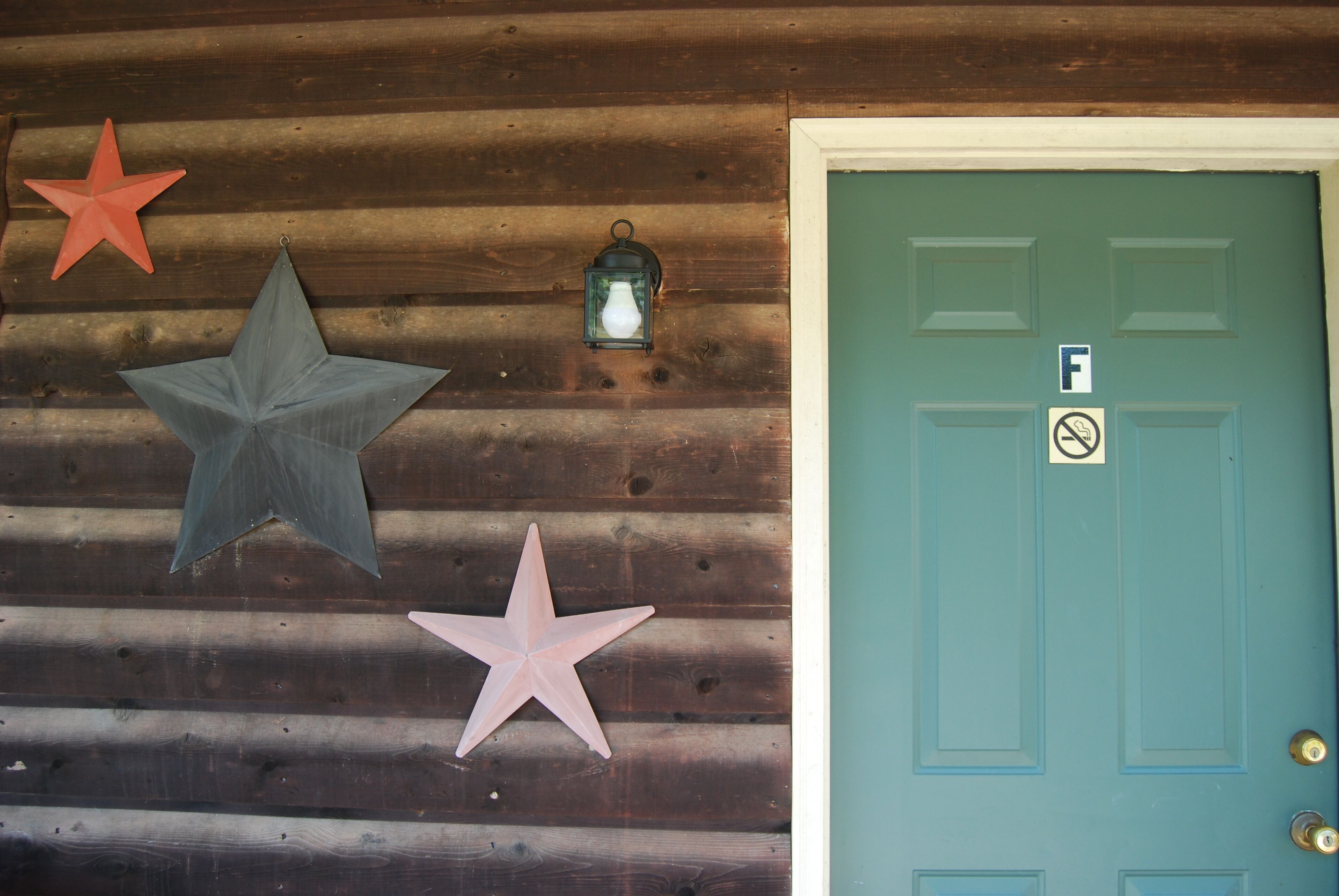 A wooden wall with three stars and a lantern.