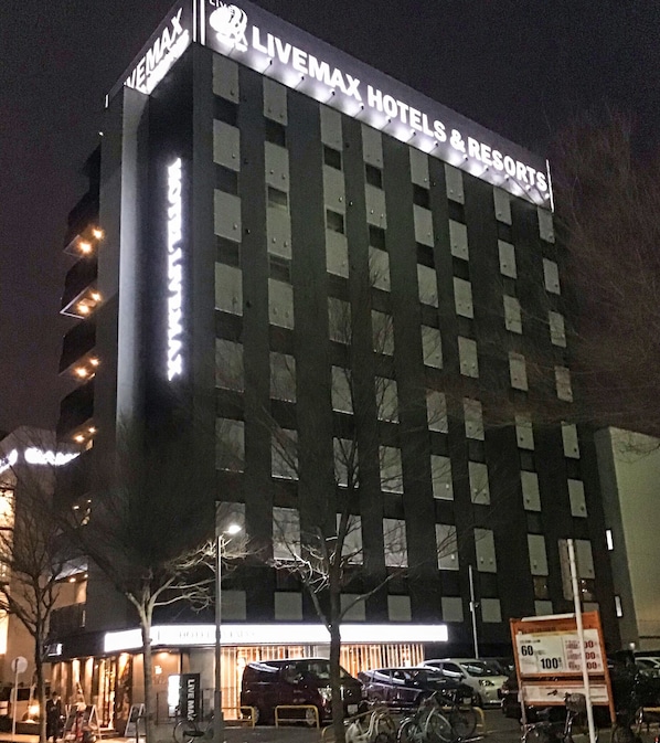 A multi-story building with the sign "LIVEMAX HOTELS & RESORTS" at the top.