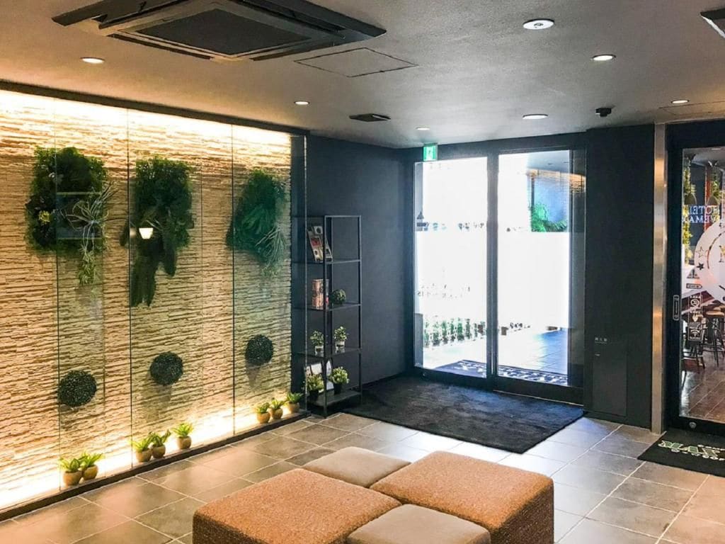 A reception area with a stone wall, potted plants, and a seating area.