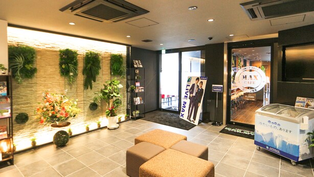 Een receptie, een zithoek en een wand met planten in de lobby.