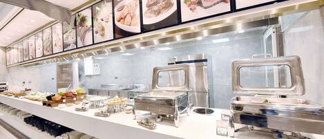 A buffet setup with various food stations, including a salad bar and a hot food station.