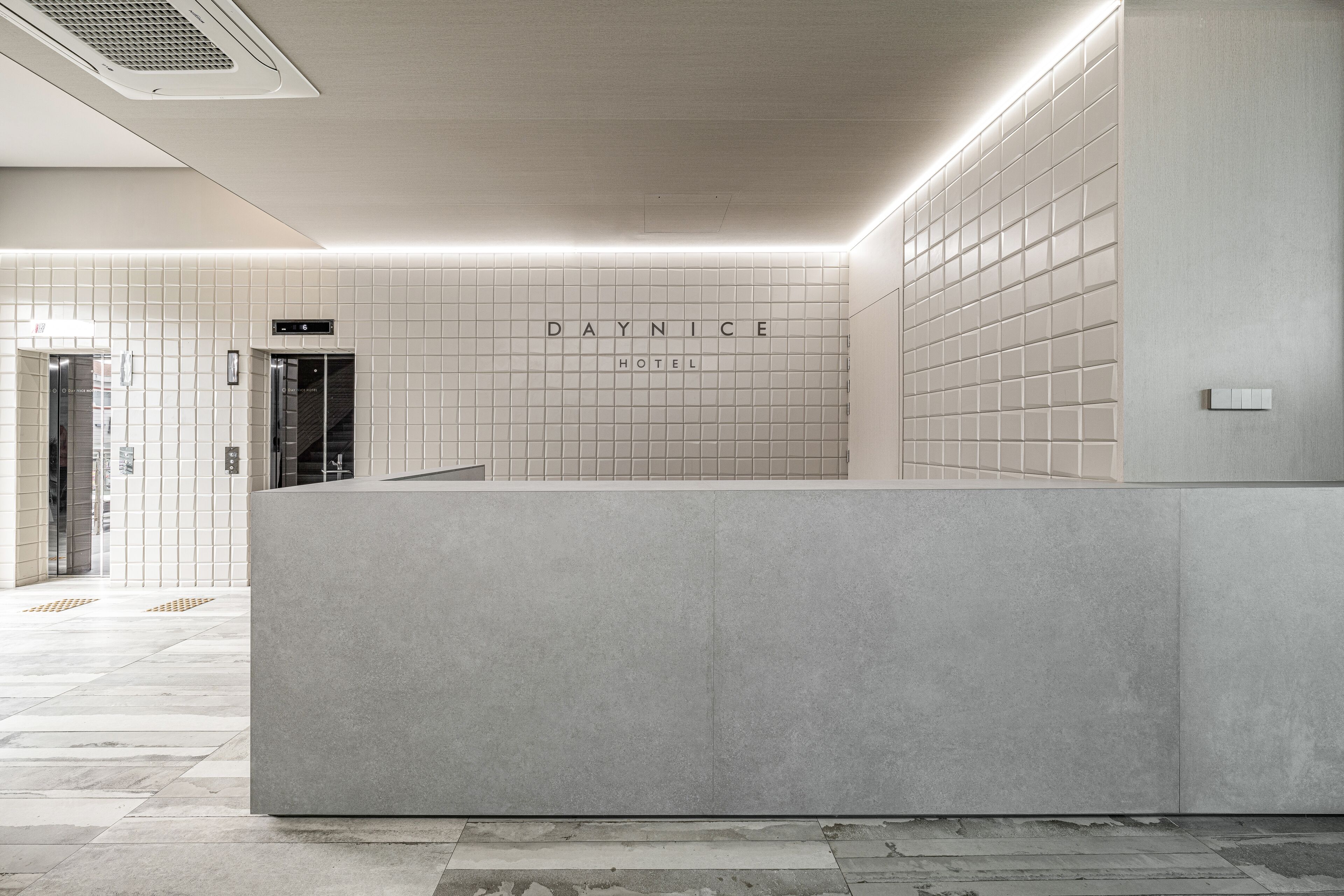 Un área de recepción con un muro de azulejos que muestra 