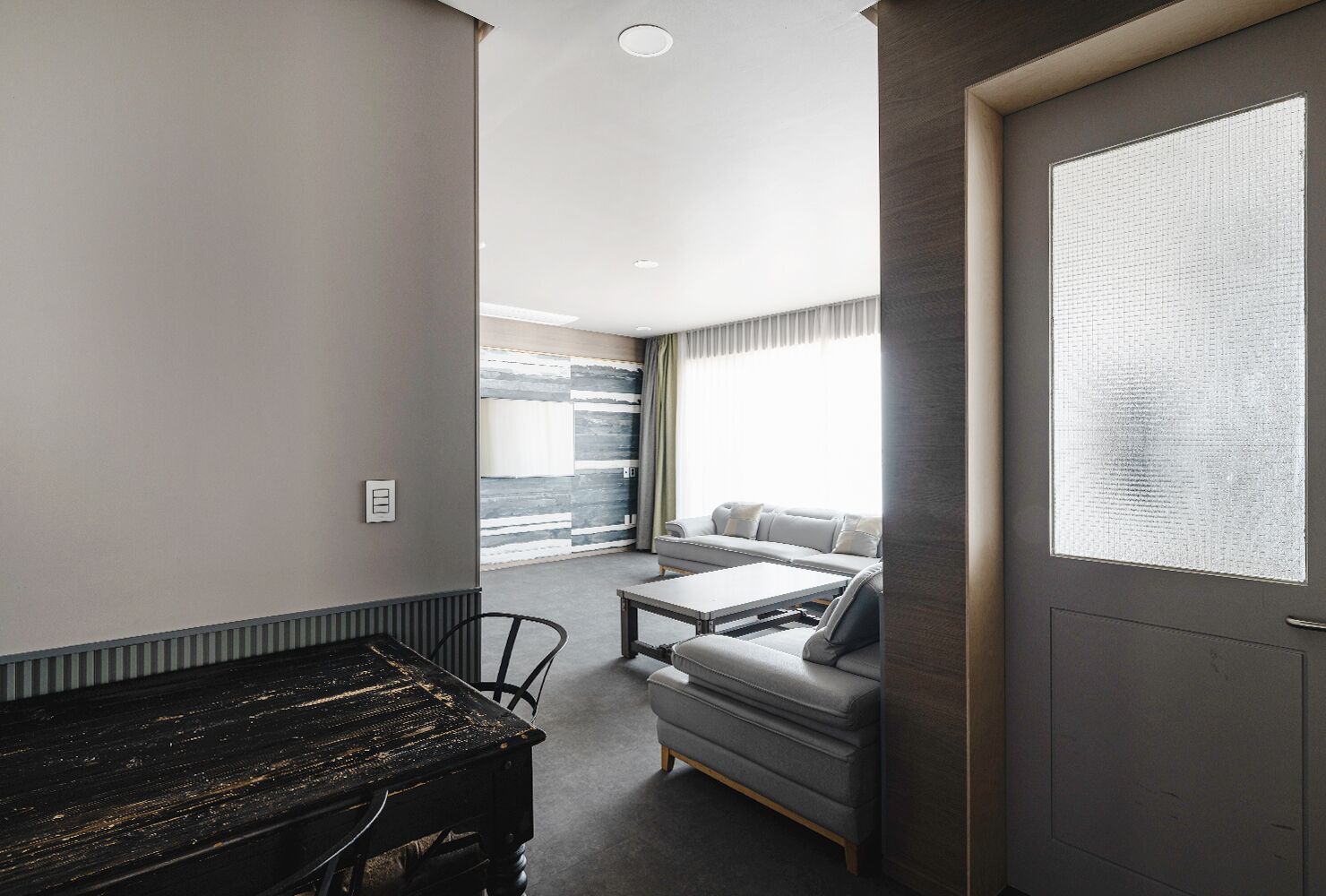 Ein modernes Zimmer mit einer Couch, einem kleinen Tisch und einem Klavier.