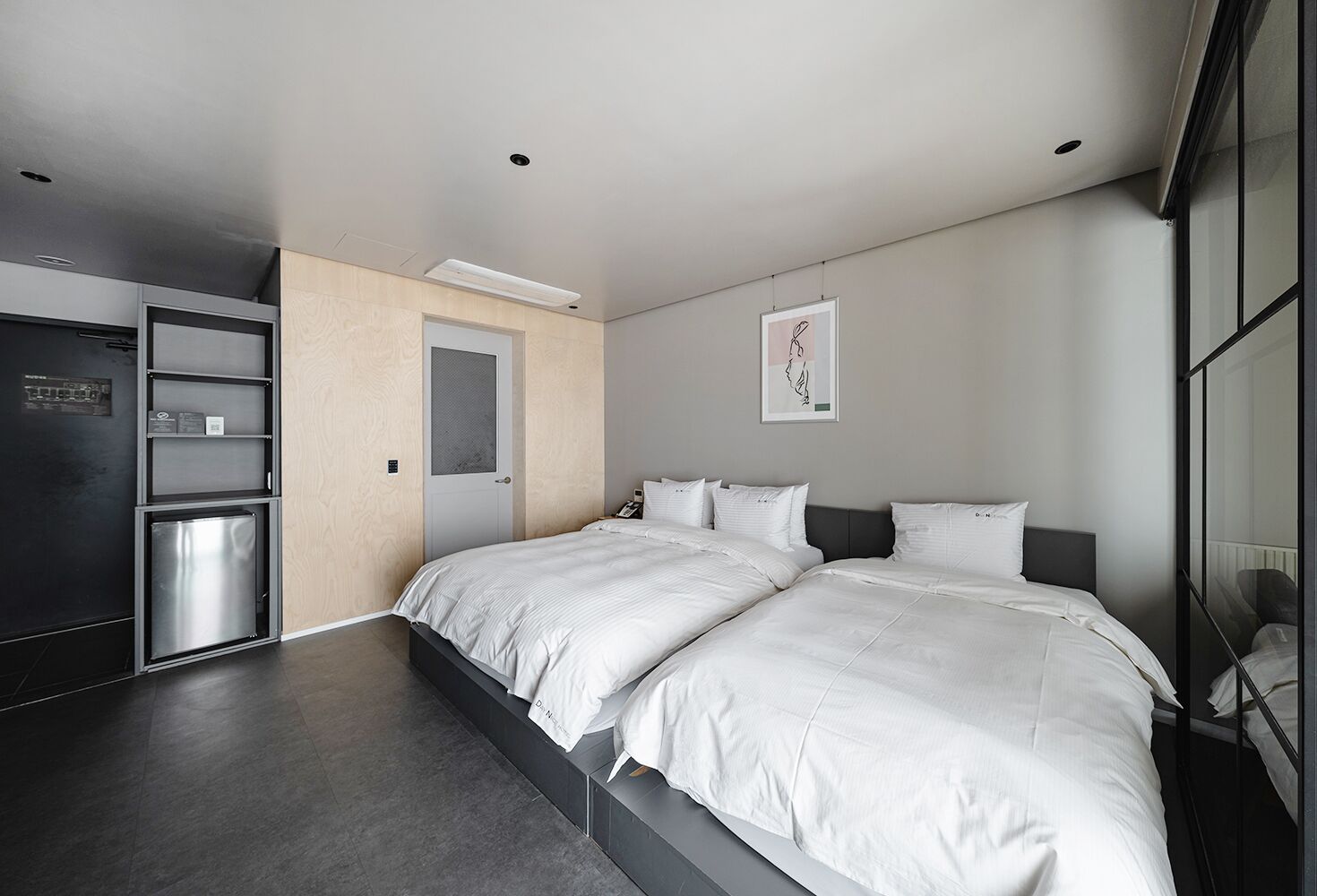 Un dormitorio moderno con una cama grande, un armario empotrado y una pequeña kitchenette.