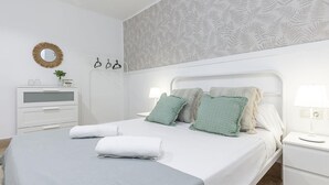 A neatly arranged bedroom with a bed, bedside tables, a dresser, and a wall-mounted mirror. - ELEGANT DESIGN APARTMENT! 2 BED -SEVILLA- WIFI - 5 PAX (Sevilla)