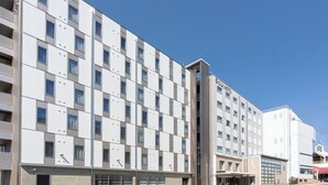 Un hôtel à plusieurs étages, doté d’une façade moderne, de balcons et offrant une vue sur un ciel dégagé.