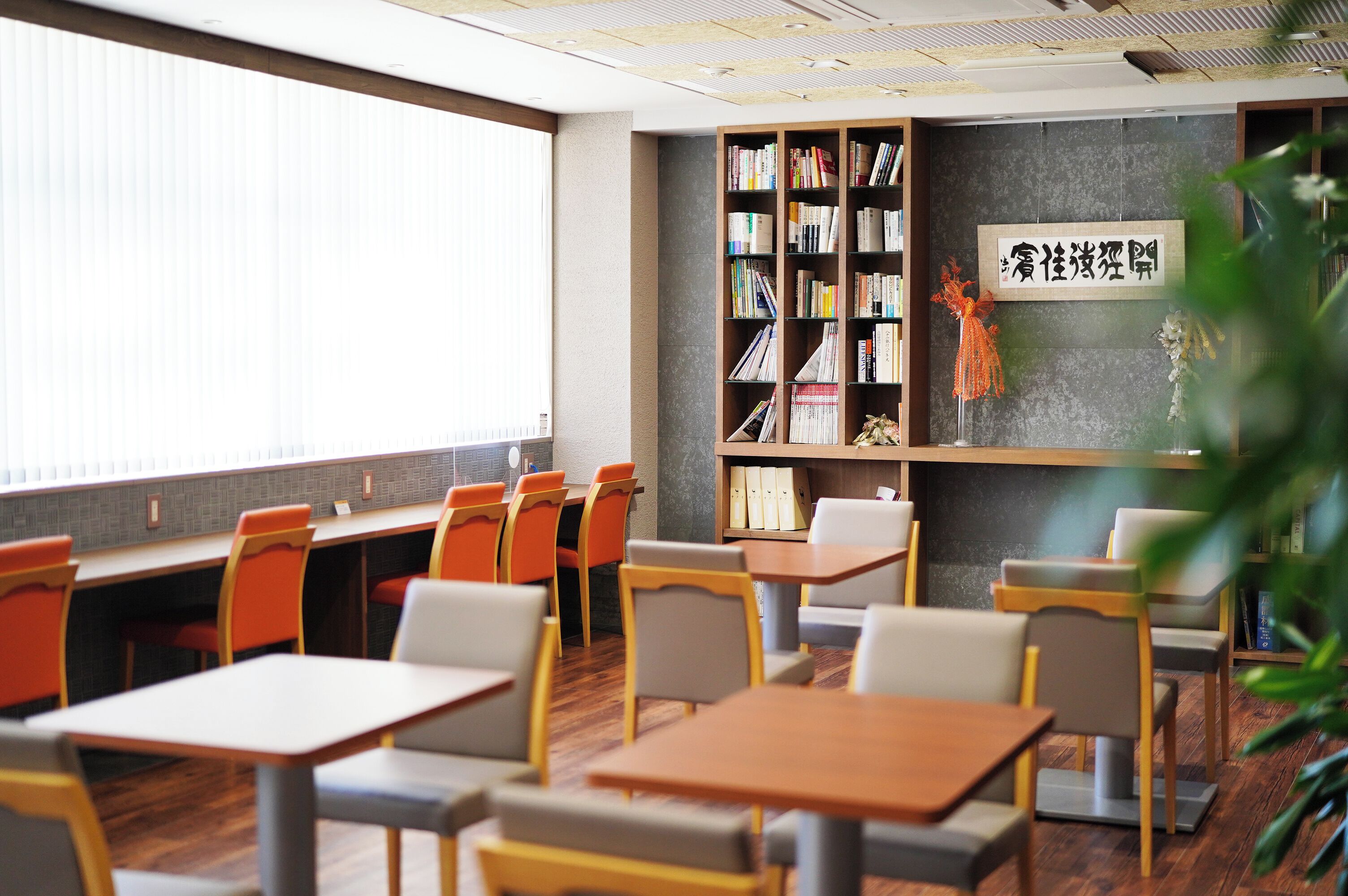 A library with bookshelves, tables, and chairs.