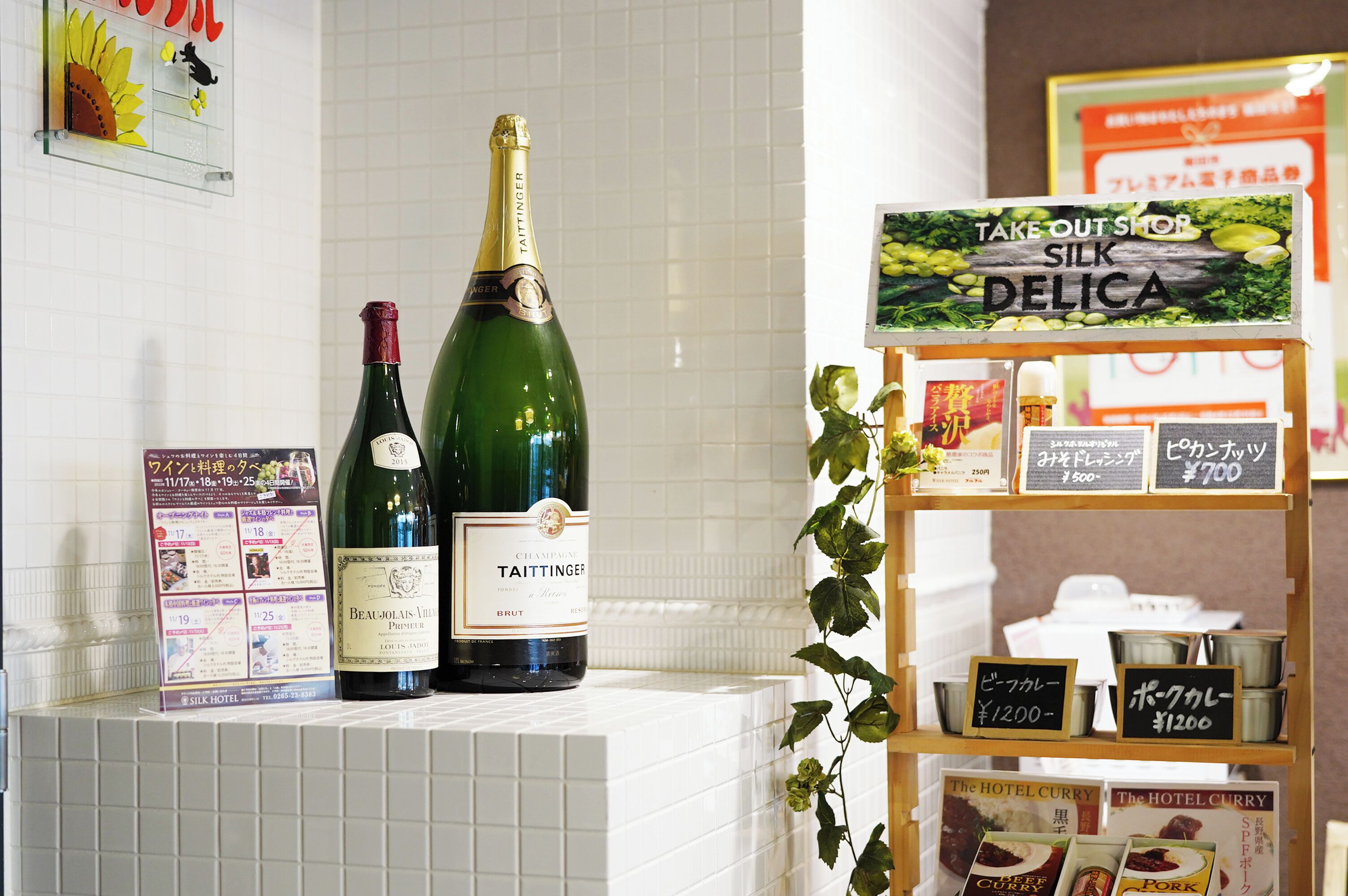 Een hotel receptie met een champagnefles, een menubord en een bord voor een afhaalrestaurant.