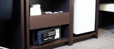 A hotel desk with a television, a refrigerator, a microwave, and a control panel.