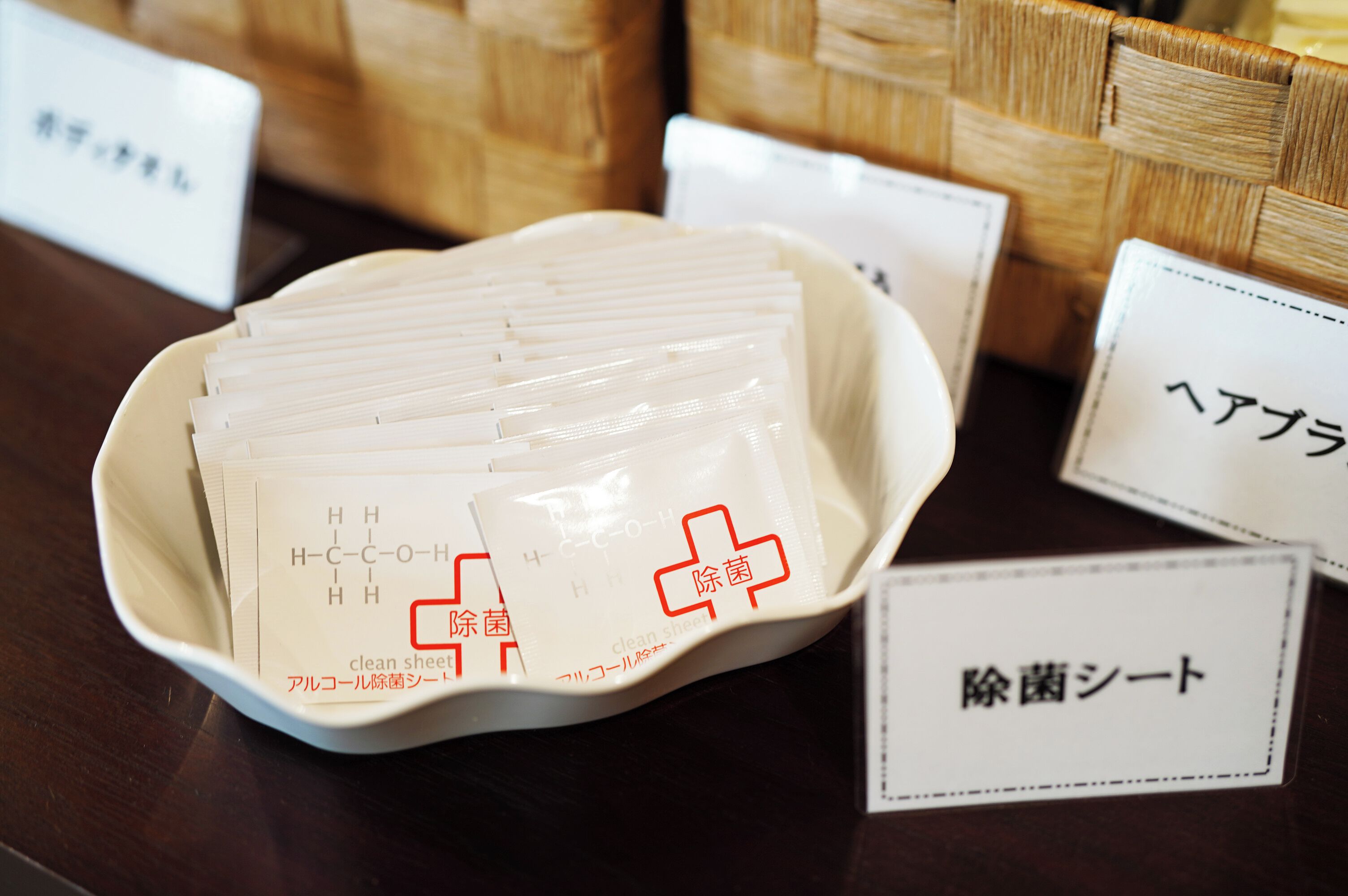 A white bowl filled with white packets labeled 'clean sheet' and 'explanation sheet' on a wooden table.