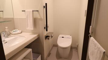 A small, modern bathroom with a sink, toilet, and towel rack.