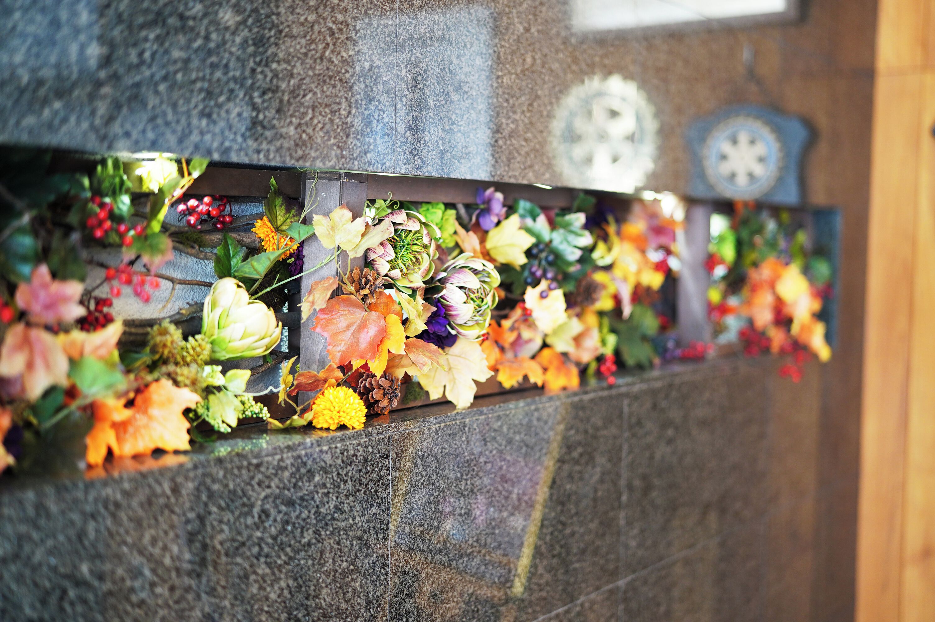 A stone wall with a floral arrangement.