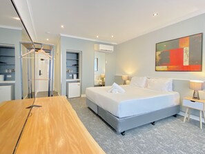 A modern hotel room with a large bed, a wooden desk, a wardrobe, and a bathroom with a shower and toilet. - Park Inn By Radisson Melbourne Carlton (Melbourne)