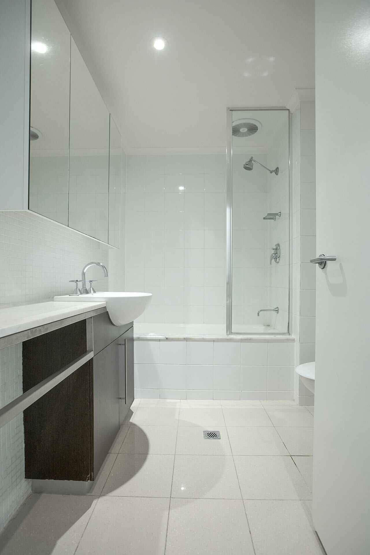 Ein modernes Badezimmer mit Waschbecken, Spiegel und Dusche.