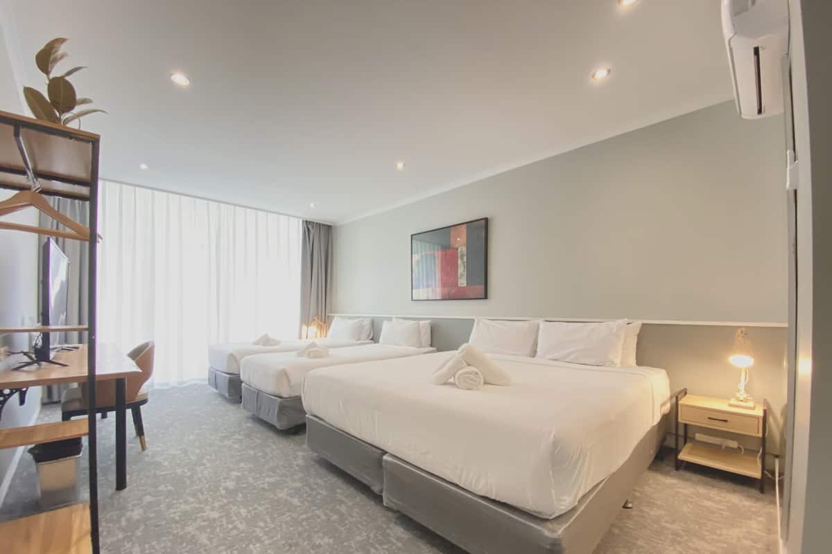 Une chambre d’hôtel moderne avec deux lits, un bureau et une chaise.