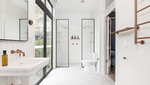 A modern bathroom with a large mirror, white sink, and toilet. - The Albert Hotel Mosman (Mosman)