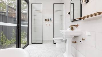 Et moderne badeværelse med badekar, toilet og bruseniche.