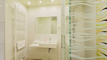 A bathroom with a white sink, mirror, and towel rack.