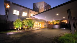A modern building with a covered entrance, a visible sign, and a well-lit exterior. - Omuta Heights (Omuta)