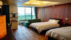 A hotel room with two beds, a sofa, a small table, and a view of the outdoors. - Omuta Heights (Omuta)