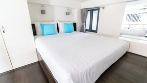 A modern hotel room with a large bed, a wardrobe, and a window with curtains. - The Haven - Lofts by the Park (Ho Chi Minh City)